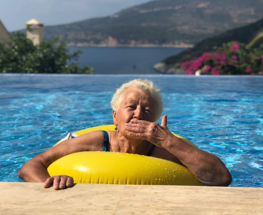 An elderly woman swimming after retirement.